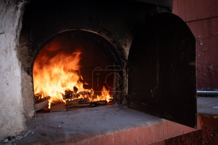 Fire and burn coals in stone oven. Oven made of bricks and clay. Clay oven for cooking food and pizza.