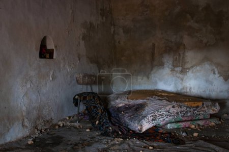 Chambre sale déserte avec vieux matelas et lit endommagé. Lieux abandonnés abandonnés.