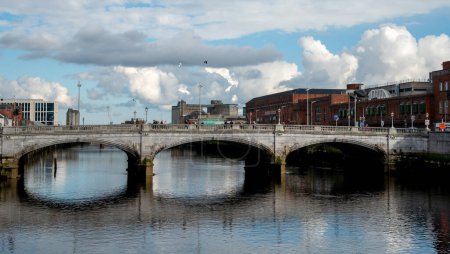 Photo for Cork, Ireland, February 24 2023: Saint partick bridge on river lee and people crossing. Cork city Ireland Europe - Royalty Free Image