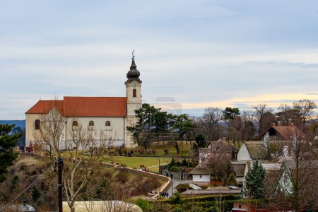 Téléchargez les photos : Tihany, Hongrie - vue sur le célèbre monastère bénédictin de Tihany (abbaye de Tihany) avec ciel bleu et nuages au lever du soleil. - en image libre de droit