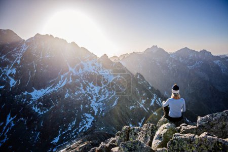 Téléchargez les photos : Belle femme blonde aime atteindre le sommet dans les Tatras slovaques et regarde la montagne Gerlach. Le pic Mala Wysoka dans les montagnes Tatra au coucher du soleil. High Tatras, Slovaquie - en image libre de droit