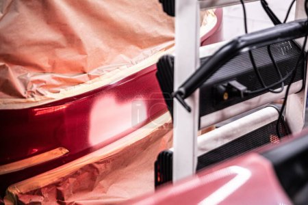 Téléchargez les photos : Ir curing the basecoat on the bumper of a red car after paint repair - en image libre de droit