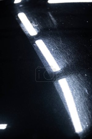 Photo for Before and after effect of a paint correction on the paintwork of a black car in a car detailing studio. Paint correction is one of the most important elements of the car detailing process. - Royalty Free Image