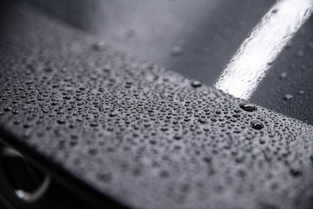 Foto de Gotas de agua en un alerón de carbono de un coche moderno. Efecto hidrofóbico. - Imagen libre de derechos