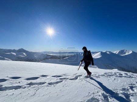 Foto de Aventurero conquistando las heladas laderas de los Tatras polacos, el sol ardiendo por encima - Imagen libre de derechos