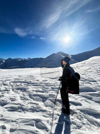 Foto de Caminante de invierno haciendo una pausa en la serena extensión de los Tatras polacos, bajo el sol de la mañana - Imagen libre de derechos
