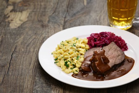 Téléchargez les photos : Sauerbraten (plat national allemand, bœuf braisé mariné) avec Rotkohl (chou rouge), Spaetzle (petites pâtes aux œufs)) - en image libre de droit