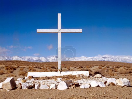 Foto de Antigua tumba sin nombre abandonada en el desierto con montañas nevadas al fondo - Imagen libre de derechos