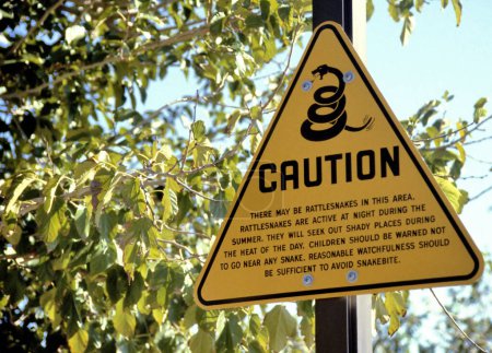 Photo for Rattlesnake sign that warns a person for dangerous situations that involve rattlesnakes. Somewhere placed in the Smith Rock State Park in Oregon, USA. - Royalty Free Image