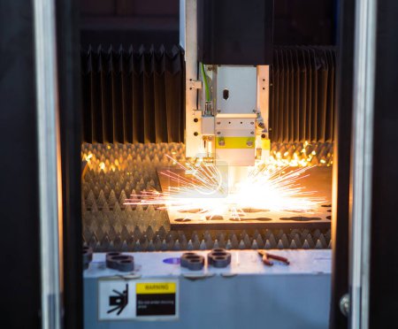 Téléchargez les photos : Machine de découpe laser à fibre CNC découpant des tôles avec étincelles volantes. Industrie métallurgique. - en image libre de droit