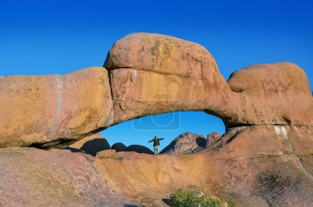 Téléchargez les photos : Active girl travels in Spitzkoppe nature reserve, woman traveler hiking near stone arches and famous rock formations in Damaraland, Namibia - en image libre de droit