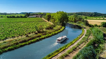 Houseboat in Canal du Midi aerial drone view from above, family water travel by boat, vacation in Southern France