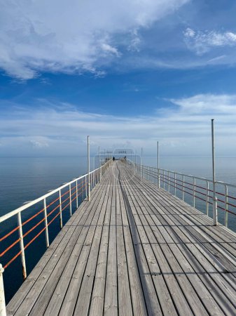 Wooden pier on the seashore. Mountains and clear water. Lake Issyk-Kul