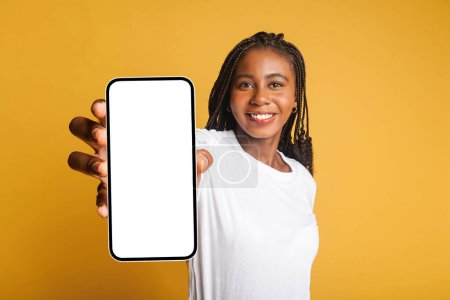 Téléchargez les photos : Girl got an unexpected pleasant deal or notification, looks at the camera with toothy smile, isolated. Amused attractive woman using smartphone, looks at the camera and smiles - en image libre de droit