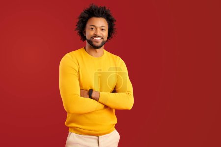 Photo for Bearded handsome man isolated on red background standing with arms crossed and looks at the camera, male entrepreneur in casual wear - Royalty Free Image