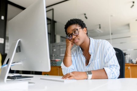 Photo for Tired and bored african female student or office employee feeling lack of energy and motivation, doing dull monotonous work, sitting in front of pc, pondering about changing job, burnout concept - Royalty Free Image