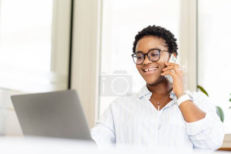 Mobile communication. Portrait of cheerful businessman in smart casual wear making call to consult, female office employee having pleasure talk on cellphone, discussing great news inside with laptop