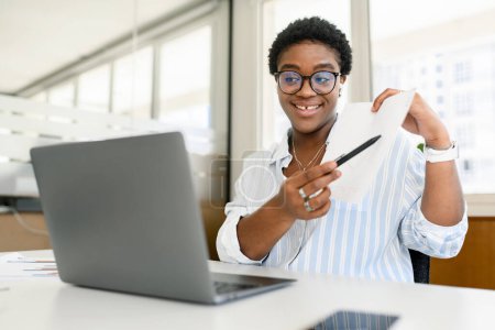 Téléchargez les photos : Divers employés de bureau concept. Femme afro-américaine utilisant un ordinateur portable pour une réunion vidéo en ligne, parler avec des collègues ou des collègues en ligne, présenter un plan d'affaires. Webinaire sur la conduite des enseignants - en image libre de droit