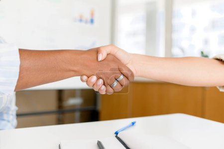 Photo for Business people shaking hands in office. Diverse colleagues greeting each other with shaking hands, faces not visible. Sign of agreement and cooperation - Royalty Free Image