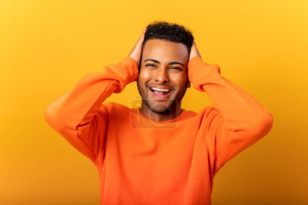 Photo for Excited shocked man holding hands on face and screaming looking at camera with open mouth, shocked bemused with news, win at lottery. Indoor studio shot isolated on yellow background - Royalty Free Image