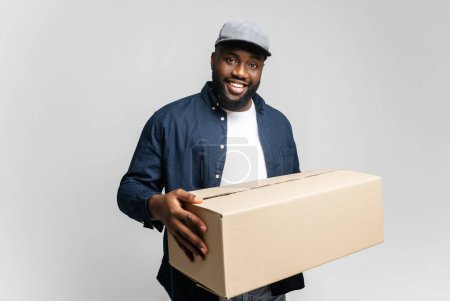 Photo for An approachable young African-American man delivers a package with a welcoming smile, creating a scene of friendly and efficient service - Royalty Free Image
