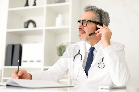 A mature doctor is captured mid-conversation during a telehealth session, displaying attentiveness and a friendly demeanor, essential for successful remote patient interactions.