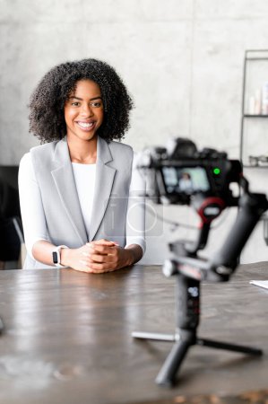 Illuminated by natural light, the businesswoman records herself with the camera, filming showreel or interview, business coach making video training lessons