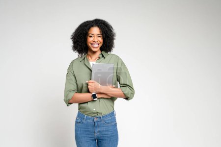 Téléchargez les photos : Dotée d'une femme afro-américaine avec une tablette, cette image rayonne d'un sentiment de convivialité et d'ouverture, parfait pour les concepts liés au service à la clientèle, au soutien en ligne ou à l'engagement communautaire. - en image libre de droit