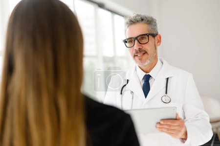 Senior doctor is shown in mid-conversation with a patient, highlighting the interactive and compassionate aspect of medical care. The importance of good communication in healthcare.