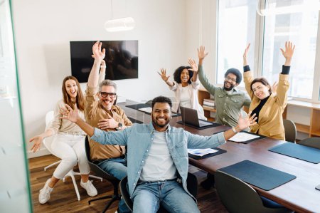 Un equipo de oficina vibrante celebra con las manos levantadas y sonrisas radiantes, creando una imagen de unidad y logros compartidos en un entorno de trabajo conjunto contemporáneo que fomenta el trabajo en equipo y la alegría.