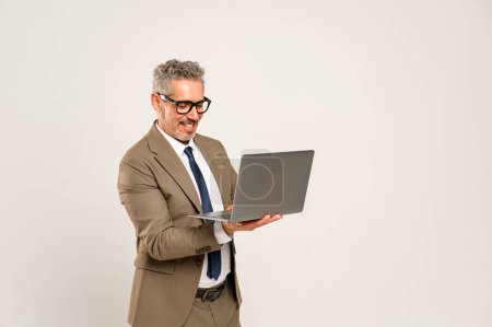 Der erfahrene Geschäftsmann strahlt über den Laptop-Bildschirm, sein formaler Anzug und die blaue Krawatte stellen eine perfekte Mischung aus Professionalität und Nahbarkeit dar. Erfolgreiche Online-Verhandlungen und Kundeninteraktionen