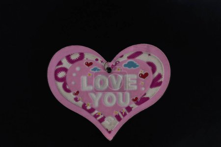 Photo for Love you message on a pink heart shape on a black background. - Royalty Free Image