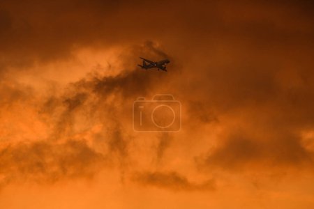 Téléchargez les photos : Coucher de soleil depuis l'avion : Vue panoramique sur les nuages éclairés par le soleil couchant - en image libre de droit