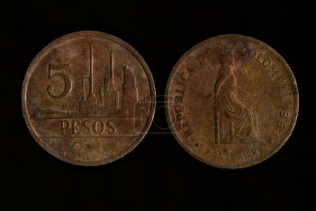 Very old copper Colombian coin, isolated on black background"