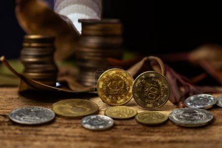 Monedas de oro y dinero colombiano sobre fondo negro: concepto empresarial de inversin y finanzas."