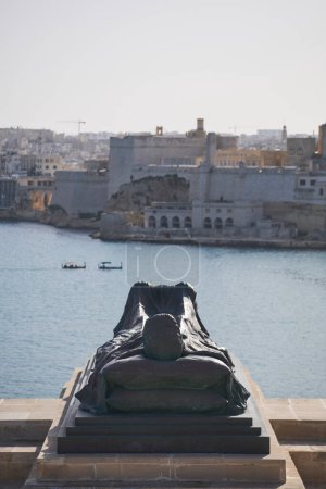 Téléchargez les photos : 2022 DÉCEMBRE Statue d'un soldat connu en mer au Mémorial de la Cloche de Siège surplombant le Fort Saint Angelo à Birgu, capitale de Malte - en image libre de droit