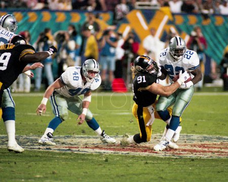 Photo for Pittsburgh Steelers DL Kevin Greene locks in on Dallas Cowboys running back Emmitt Smith during Super Bowl XXX which was played on January 28, 1996, in Tempe, Arizona - Royalty Free Image