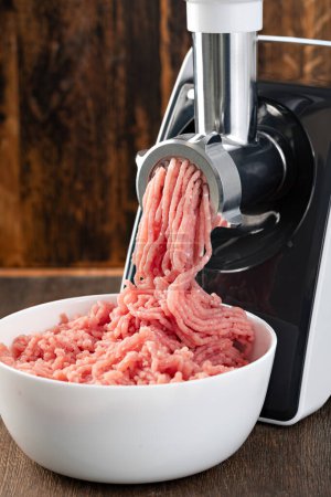 Photo for Electric meat grinder on a wooden background - Royalty Free Image