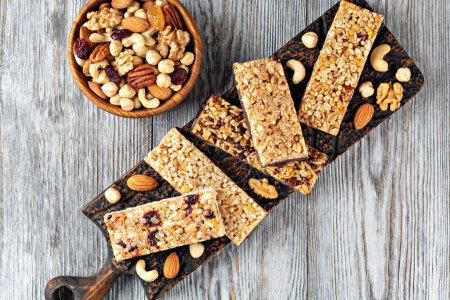 Photo for Granola bars with nuts and dried fruits on wooden background - Royalty Free Image