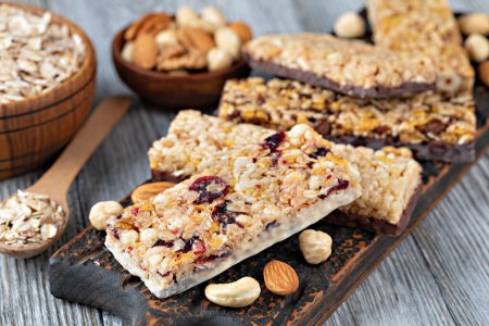 Photo for Granola bars with nuts and dried fruits on wooden background - Royalty Free Image