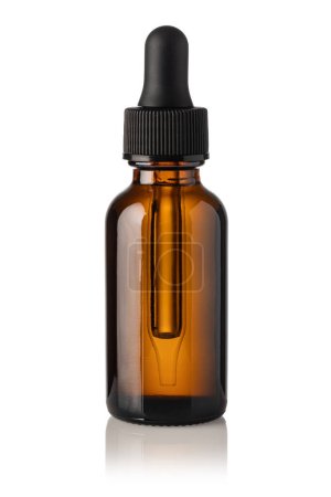 Foto de Caída de una pipeta en una botella cosmética, aislada sobre fondo blanco - Imagen libre de derechos