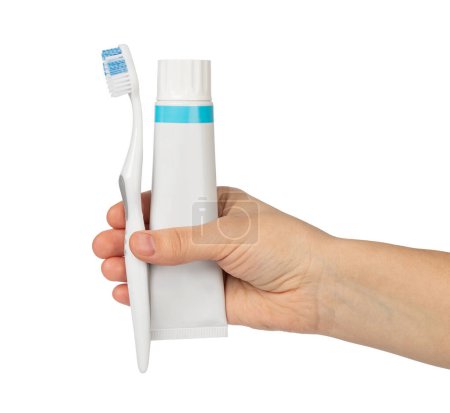 Foto de Mano de mujer sosteniendo tubo blanco de pasta de dientes y cepillo de dientes aislados en un blanco - Imagen libre de derechos