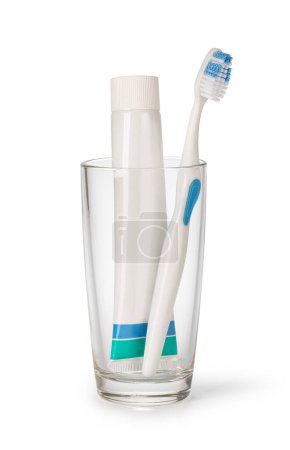 Foto de Cepillo de dientes y pasta de dientes en vidrio sobre fondo blanco - Imagen libre de derechos