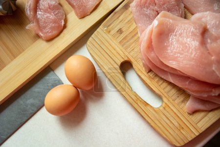 Téléchargez les photos : Œufs et viande crue sur une planche de cuisine, vue sur le dessus - en image libre de droit