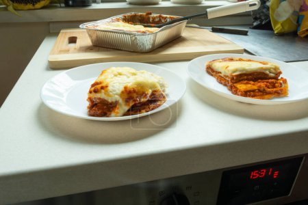 Photo for Pieces of baked fresh lasagna on plates, food from the market - Royalty Free Image