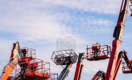 Photo for Articulated boom lift. Aerial platform lift. Telescopic boom lift against blue sky. Mobile construction crane for rent and sale. Maintenance and repair hydraulic boom lift service. Crane dealership. - Royalty Free Image