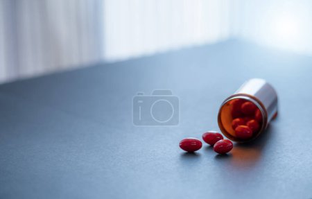 Téléchargez les photos : Pilules de capsule rouge et bouteille de drogue en plastique brun. Codéine et guaifenesin capsules pour soulager la toux. Médecine contre la toux. Opioïdes ou narcotiques. Médicament sur ordonnance. Médicament anti-toux. - en image libre de droit