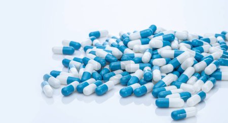 Pile of blue and white capsule pills. Pharmacy product. Prescription drug. Healthcare and medicine. Pharmaceutical industry. Pharmaceutical science. Prescription medication. Capsule pill production.
