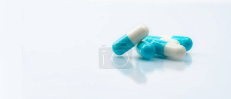 Photo for Blue-white capsule pills on white background. Pharmacy banner. Prescription drug. Healthcare and medicine. Pharmaceutical industry. Pharmaceutical science. Drug safety. Prescription medication. - Royalty Free Image