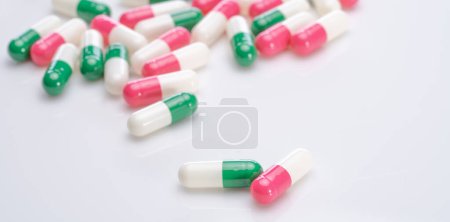 Capsules pill spread on white background. Prescription drugs. Capsule pill production. Green, pink, and white color capsule pills. Pharmaceutical industry. Medication and pharmacology. Health care.